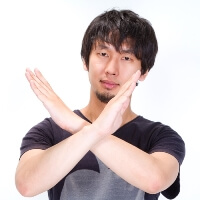 手で×を作る男性