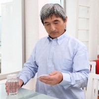 薬を飲もうとする男性