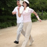 大股でウォーキングする夫婦