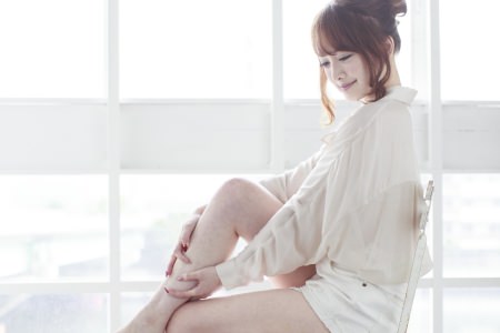 足のツボを押す女性